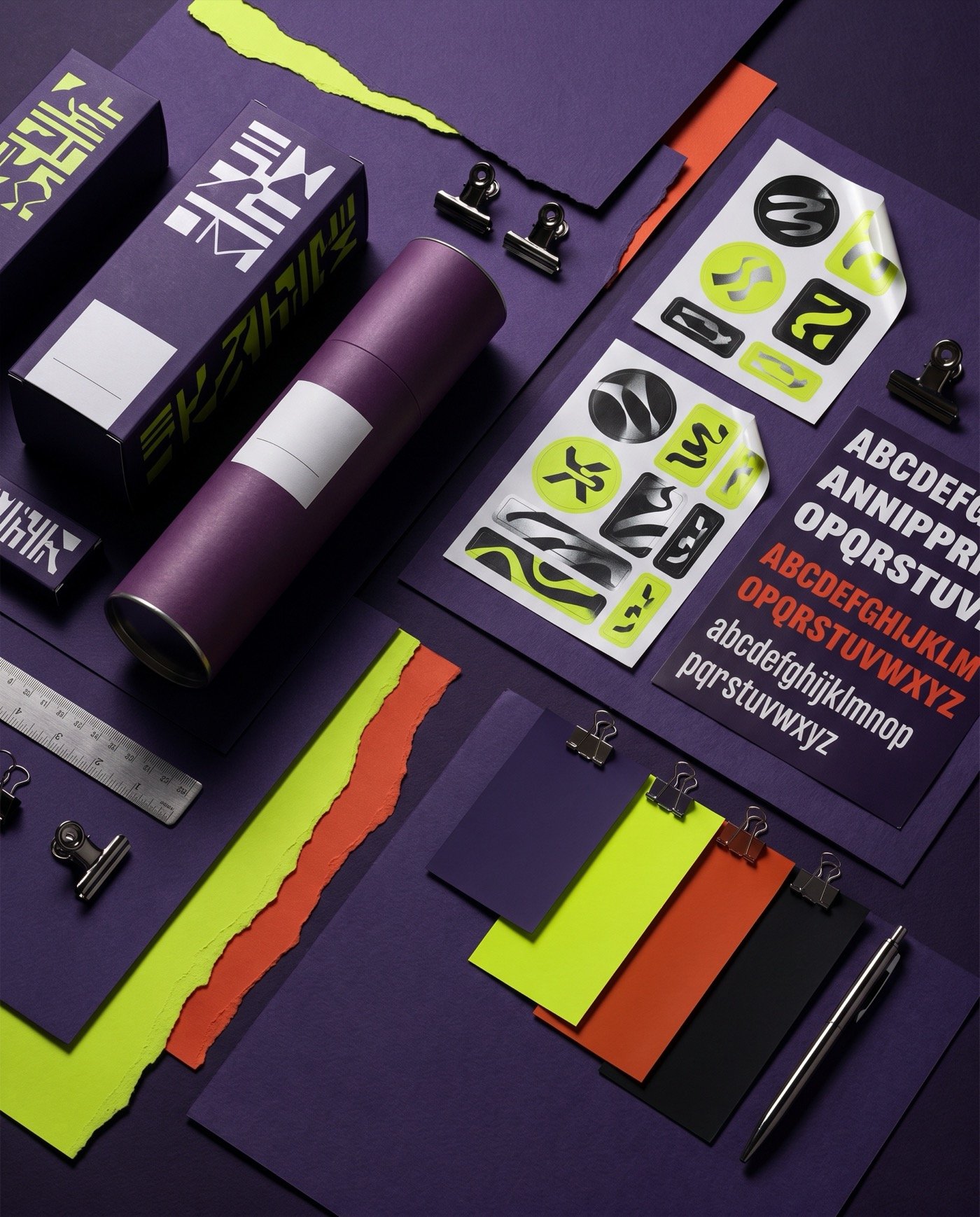 Planche de branding violet, vert acide et orange avec packaging et stickers